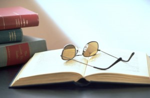 Open books with glasses lying on top.